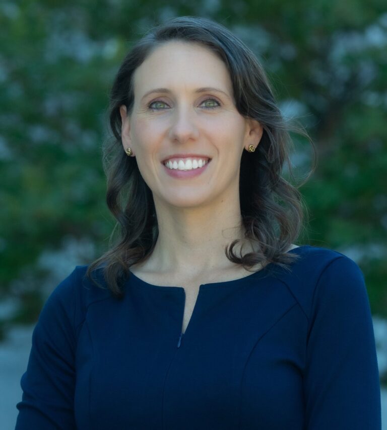 Nicole Devencenzi stands in front of the San Joaquin County courthouse in a blue dress profile image